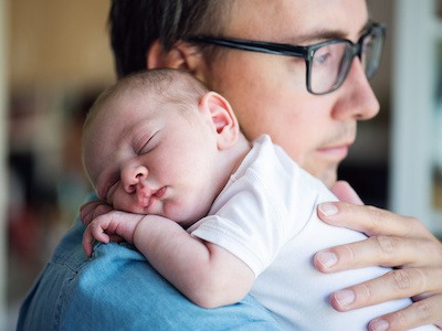 Father holding child after navigating Texas paternity laws to establish parentage