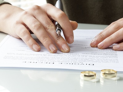 Spouse signs divorce decree after working with divorce lawyer near her for legal representation in Texas