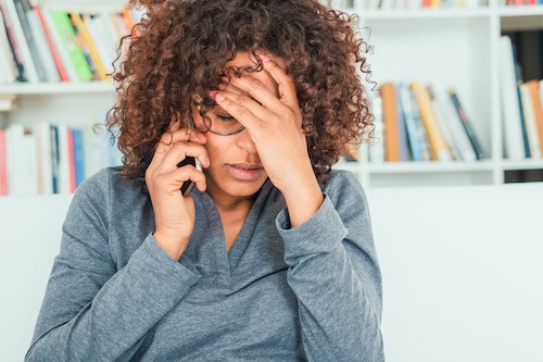 A frustrated woman on the phone after finding out that her husband refuses to pay their divorce settlement