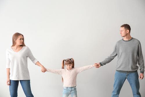 A child being pulled between her mother and father with one parent not realizing that keeping a child away from the other parent can backfire