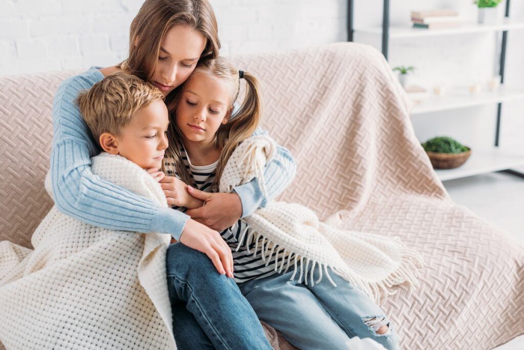 Mom hugging and protecting her children